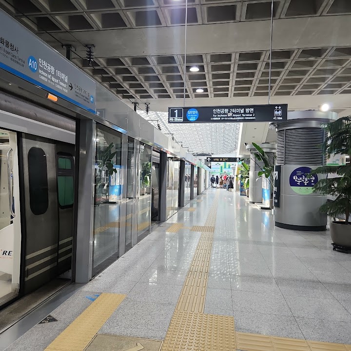 인천국제공항 제1여객터미널역의 승강장에서 공항철도 안내 표지와 열차 승강장 문이 보인다。