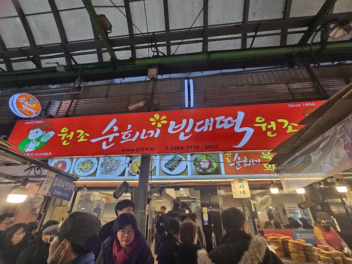 広蔵市場で油の香りに食欲をそそられながら、焼きたての緑豆チヂミが山のように積まれた屋台を見つけて、ここで座って食べられる安心感までうれしくなりました。