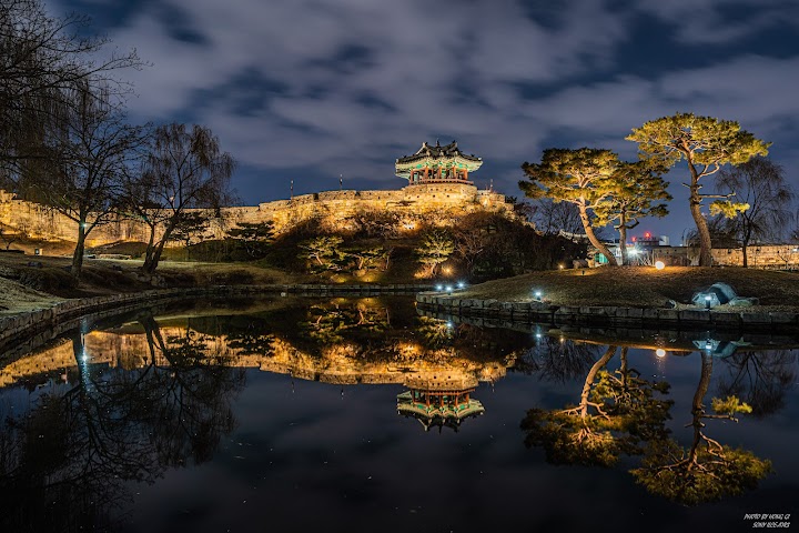 水原華城の夜景。ライトアップされた訪花随柳亭が、鏡のような池の水面に美しく映り込んでいます。静寂な夜の散歩は、昼間の疲れを癒やしてくれました。