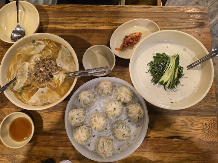 明洞餃子の看板メニュー、カルグクスとマンドゥが並ぶテーブル。熱々のとろみスープと肉汁たっぷりの蒸し餃子は、優しい朝ごはんの後にぴったりな、食欲をそそるエネルギーチャージになりました。