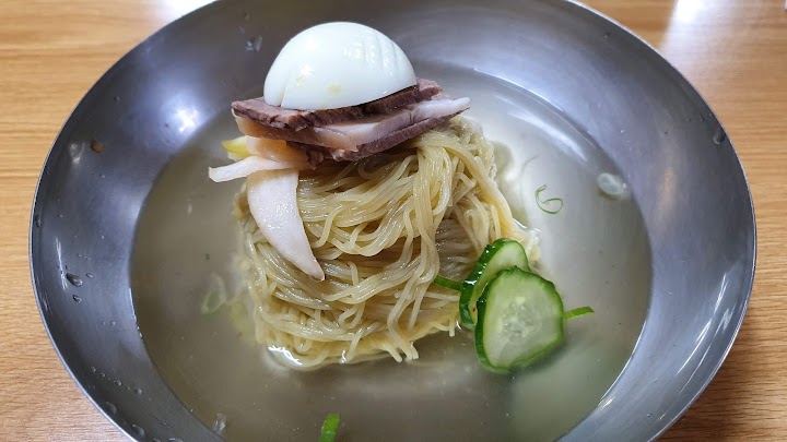 真味平壌冷麺の澄んだスープと美しく盛られた麺。一口すする前に広がる、ほのかな蕎麦の香りがたまりません。