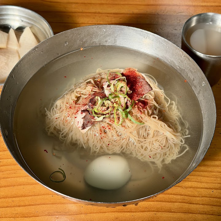 ソウルの平壌麺屋で提供された、透き通ったスープに美しい麺が泳ぐ冷麺。