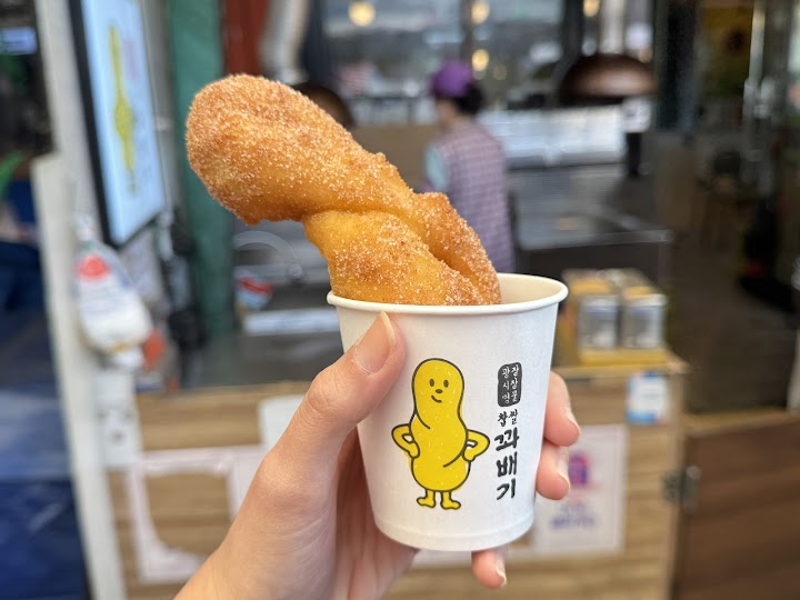 広蔵市場の出口付近で、お土産を片手に、砂糖がたっぷりまぶされた揚げたてのクァベギをパクり。外はカリッ、中はもちもちで、市場歩きの疲れが吹き飛ぶ甘さでした。