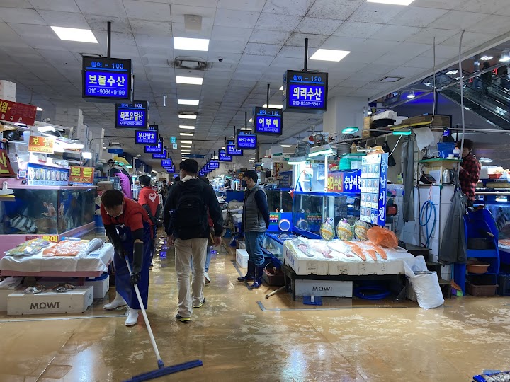 鷺梁津水産市場の活気ある通路を進むと、床が濡れていて潮の香りが漂い、いよいよ市場散策が始まるワクワク感に包まれます。