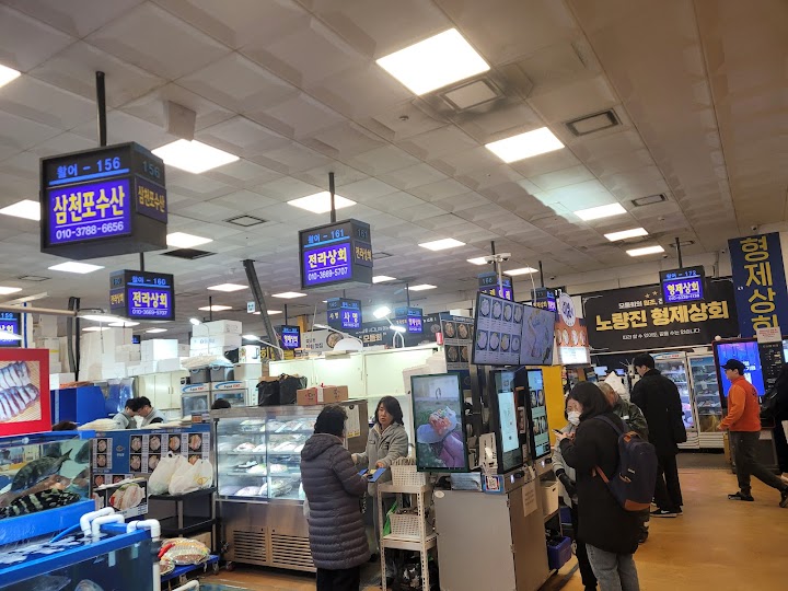 鷺梁津水産市場の有名店「兄弟商会」の注文カウンターで、活気ある市場の雰囲気を感じながら新鮮な魚を選びました。