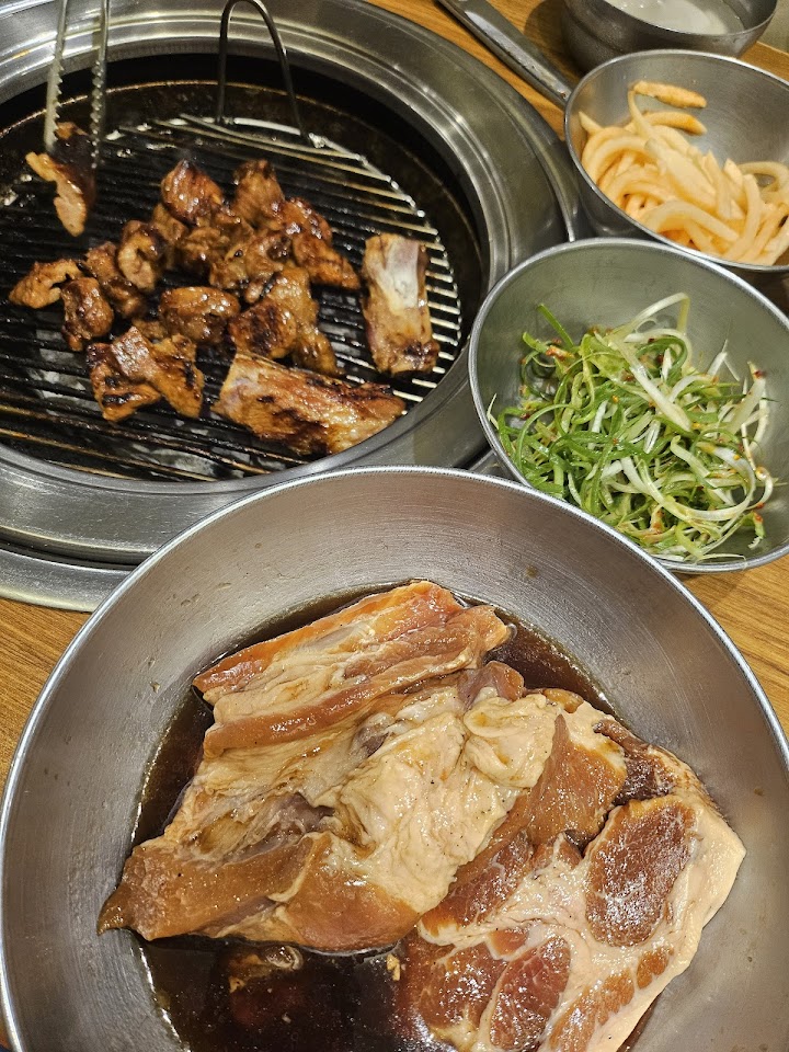 麻浦の돼지갈비通りにある元祖ジョバッチッで、香ばしい匂いに包まれながら、運ばれてきた味付け豚カルビと並べられたパンチャン(おかず)を見ると、焼き肉への緊張が期待に変わりました。