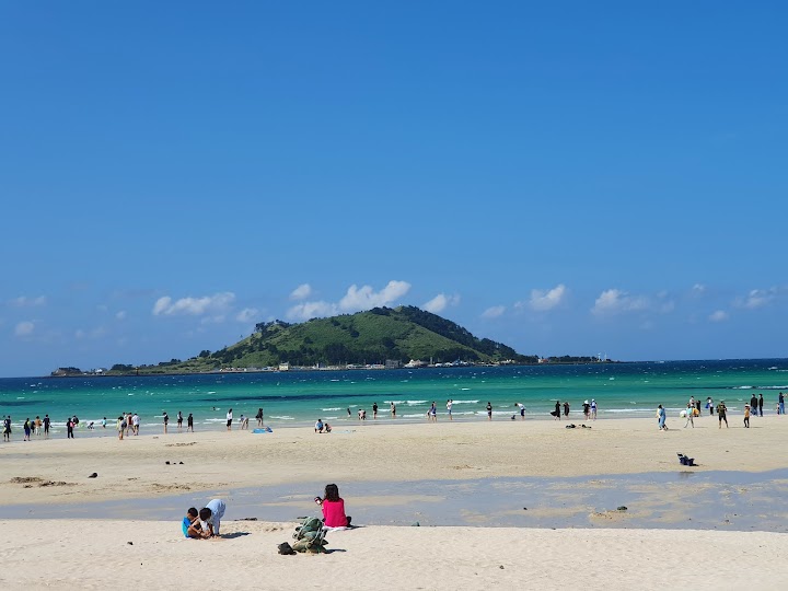 済州島の協才海水浴場は、白い砂浜とエメラルドグリーンの海、そして遠くに見える飛揚島の景色が本当にきれいで、歩いているだけで旅の疲れが癒やされます。