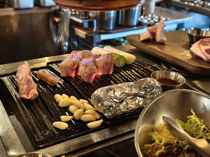ソウルで大行列必須の金豚食堂にて、ついに目の前で焼かれる極厚のサムギョプサル。ニンニクもたっぷりで、香ばしい香りが漂います。